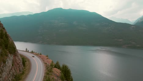 Aerial-tracking-shot-of-a-car-driving-past-Slocan-Lake