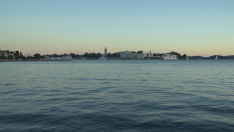 Toma-Estática-Del-Establecimiento-Del-Casco-Antiguo-De-Zadar-Con-Un-Mar-Tranquilo-Y-Pacífico-En-Primer-Plano