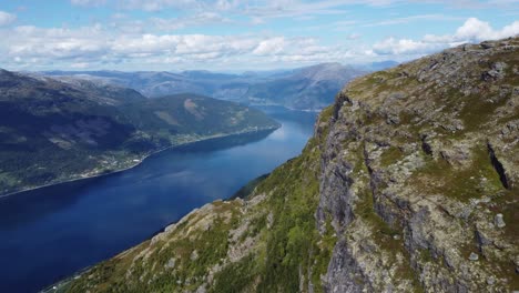 Hardangerfjord-Sorfjorden-Hacia-Utne-Visto-Desde-La-Ruta-De-Senderismo-Queens-Sobre-Lofthus-En-Noruega---Antena-Desde-Un-Acantilado-Empinado-En-Una-Montaña-Alta-Con-Una-Vista-Impresionante