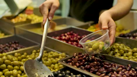 Vendor-Scooping-Various-Salted-Olives-Into-The-Tub-On-The-Mahane-Yehuda-Market-in-Jerusalem,-Israel