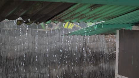 Dripping-rainwater-during-tropical-storm-from-shed-roof-on-exotic-island,-leaking-water