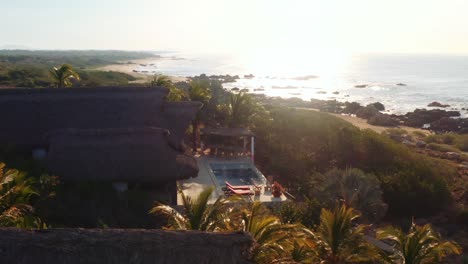 Slow-drone-pan-around-luxury-rental-villa-in-oaxaca-mexico,-ocean-front-4k-aerial-sunrise