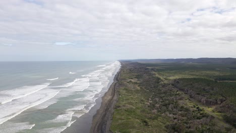 Wide-angle-aerial-orbit-showing-the-long-western-coastline-of-New-Zealand's-north-Island-with-tyre-tracks-in-the-black-sand-below