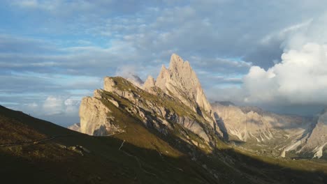 Close-orbit-drone-shot-of-top-of-a-mountain-in-a-sunny-morning-in-Dolomites,-Italy
