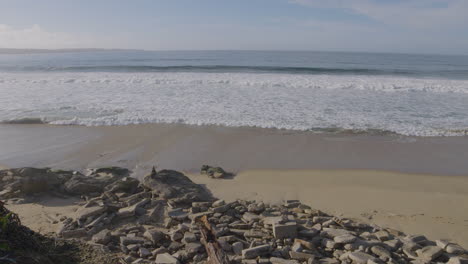 Slow-motion-shot-peaceful-rolling-waves-onto-a-rocky-shore-on-the-west-coast-of-California