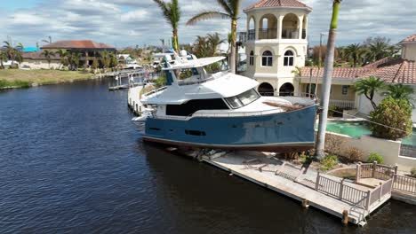 Boat-docked-on-pier-with-luxury-villa-on-coast-of-Florida,-America