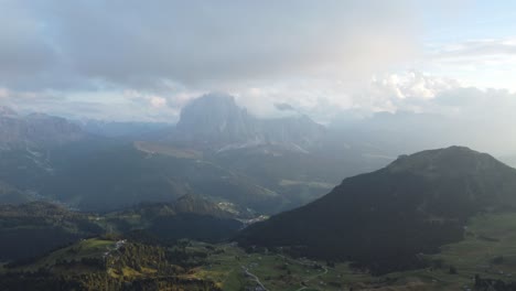 Luftaufnahme-Einer-Kleinen-Zivilisation-Auf-Dem-Boden-Mit-Den-Bergen-Der-Dolomiten-Im-Hintergrund-Mit-Dem-Nebel