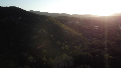 Few-houses-on-the-hills-surrounded-by-lot-of-natural-greenery,-drone-areal-footage