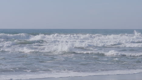 Slow-motion-shot-of-waves-crashing-along-the-beach-of-Marina-State-Beach-Monterey-Bay-California