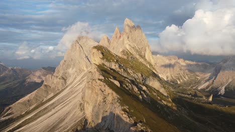 Orbit-drone-shot-of-top-of-a-mountain-in-a-sunny-morning-in-Dolomites,-Italy