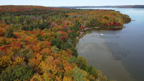Cinematic-drone-shot-of-Rock-Lake-passing-through-colorful-autumn-foliage-of-Algonquin-park,-Ontario