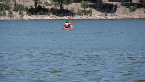 Two-people-paddling-on-kayak-at-pantano-de-San-Juan-lake,-Madrid