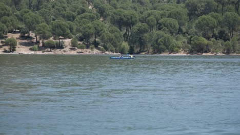 Dos-Personas-En-Un-Kayak-Azul-Separado-Remando-En-El-Lago-Pantano-De-San-Juan,-Madrid