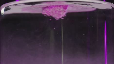 pink-bath-salt-held-in-water-with-purple-fingernails
