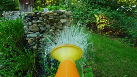 POV-shot-of-a-watering-can-pouring-plants-in-a-garden-to-grow-vegetables-or-fruits