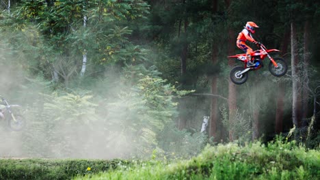 Gruppe-Von-Motocross-Fahrern,-Die-Beim-Waldgeländerennen-Einzeln-In-Die-Luft-Springen