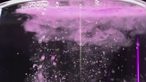 pink-carbonated-bath-salts-dropped-in-water-with-bubbles-rising-in-slow-motion