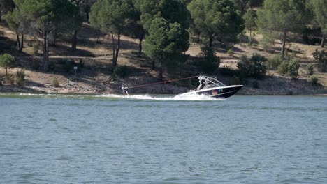 Mann-Wasserski-Auf-See-Von-Wasserfahrzeugen-Am-See-Pantano-De-San-Juan,-Madrid-Geschleppt