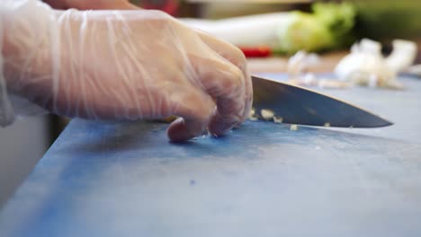 Cutting-garlic-into-small-pieces-on-a-blue-cutting-board-in-a-sushi-restaurant