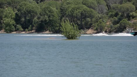 Man-water-skiing-on-calm-water-of-lake-reservoir-pantano-de-San-Juan,-Madrid