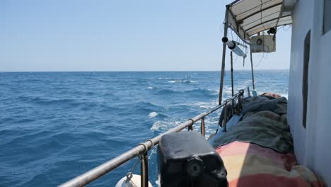 Slow-motion-view-down-the-starboard-side-of-a-fishing-boat-as-it-rides-through-open-waters