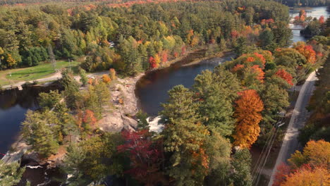 Fliegen-über-Rot-orangefarbenen-Herbstfarbenen-Bäumen-Und-Kleinen-Stromschnellen-In-Einem-Atemberaubenden-Fluss