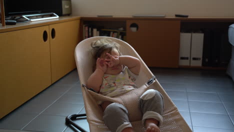 Impatient-tired-bored-baby-toddler-bouncing-up-and-down-chair-at-home,-static