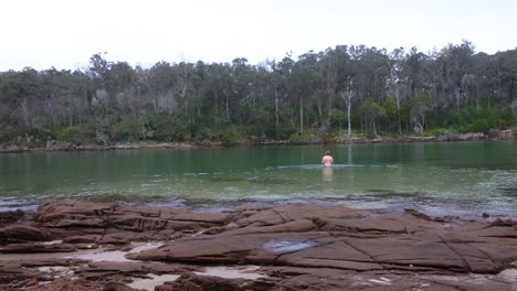 A-bearded-man-goes-swimming-in-a-national-park-bay-in-an-Australian-wilderness