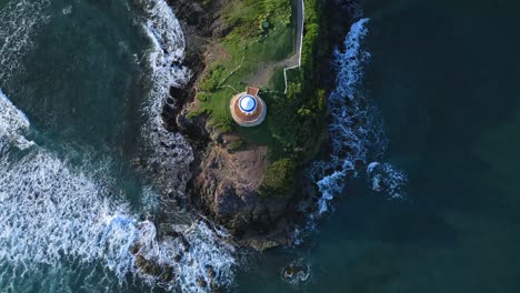 Aerial-top-down-shot-of-pavilion-on-hill-surrounded-by-waves-of-ocean-in-summer---Senator-Resort-Hotel,Puerto-Plata