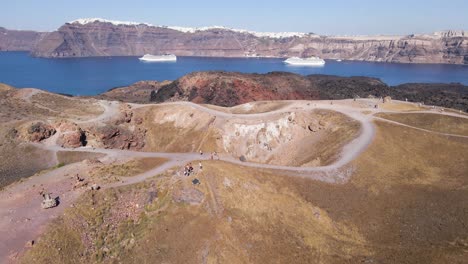Aerial-view,-rotating-over-volcano-crater-at-Santorini-island,-Greece-in-slow-motion