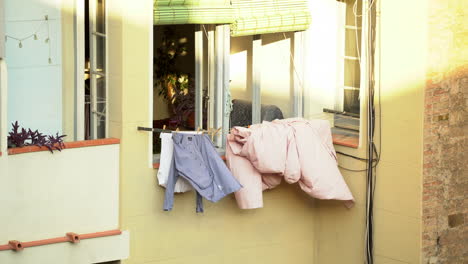 Clothes-drying-hanging-outside-window-balcony,-sunny-day,-static