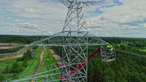 Man-fixing-and-repairing-electrical-mast-surrounded-by-forest-and-nature