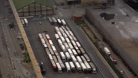 Many-trucks-stuck-in-parking-space,-logistics-warehouse,-aerial-view