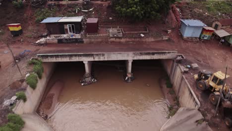 Steigende-Luftaufnahme-Von-Abwasser,-Das-In-Einem-Großen-Offenen-Sturmabfluss-Ghana-Fließt