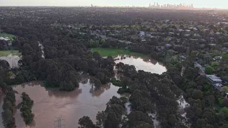 Vista-Aérea-Sobre-El-Parque-De-Pisos-De-Yarra-Inundado-Con-Agua-De-Inundación-El-14-De-Octubre-De-2022,-Con-El-Horizonte-De-La-Ciudad-De-Melbourne-En-El-Fondo