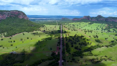Aerial-view-of-the-Brazilian-Cerrado-,-a-big-mountain,-blue-sky-and-a-highway---Pantanal,-Brazil
