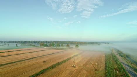 Aerial-perspective-of-a-fog-covered-plowed-cropland-on-a-sunny-day