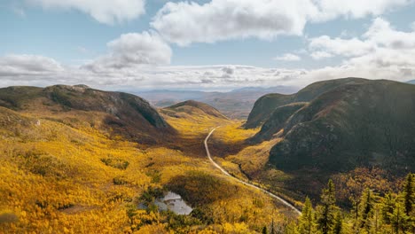 Mountaintop-view-of-vibrant-autumn-forest-valley-covered-in-bright-golden-yellow-trees,-Quebec-Canada,-time-lapse