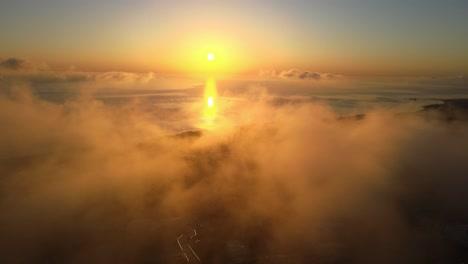 Sonnenaufgang-Am-Meer-Aus-Der-Luft,-Der-Aus-Den-Wolken-Auf-Der-Insel-Santorini,-Griechenland,-Fliegt