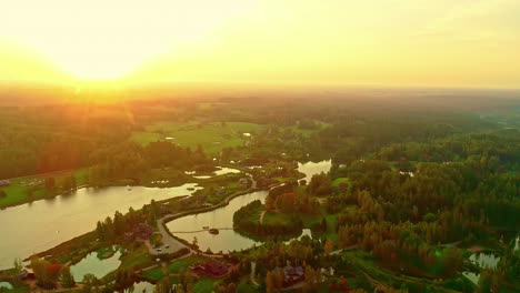 Sunset-over-landscape-with-lakes,-aerial-drone-view