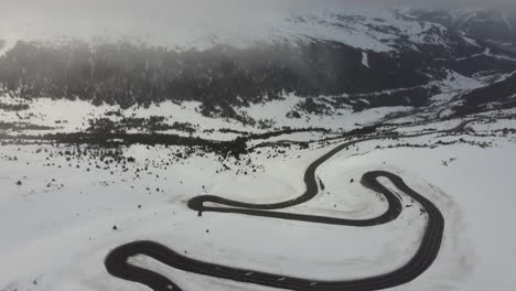 Cold-white-snowy-mountain-travel-landscape-twisty-road-in-Andorra,-aerial-view