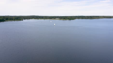 Beautiful-drone-shot-flying-over-lake-at-Stony-Creek-Metropark-in-Michigan
