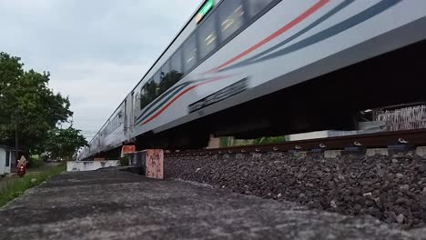 Color-video-in-format-retro-vintage-style-of-Train-white-Diesel-electric-Locomotives-at-line-and-sail-through-rail-chopper-before-entering-country-railway-station-of-Indonesia