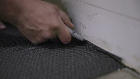 Close-up-footage-of-a-man-cutting-a-tile-by-the-wall-with-a-utility-knife