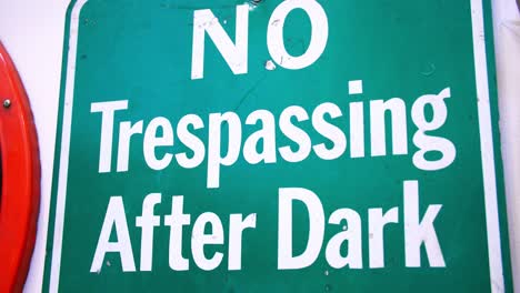 Close-up-footage-of-a-road-sign-that-says-"No-Trespassing-After-Dark