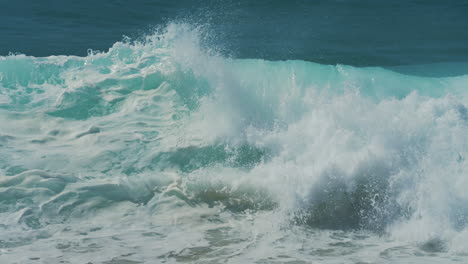 Close-up-slow-motion-shot-of-sea-waves-breaking-on-sandy-coastline-in-Portugal
