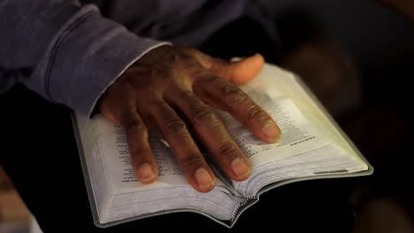 Rezando-A-Dios-Con-La-Mano-En-La-Biblia-Con-Fondo-Gris-Almacen-De-Video