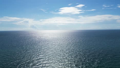 Drone-shot-moving-towards-the-ocean-horizon-and-sun