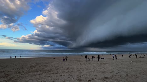 Wide-angle-panning-view-at-the-beach-in-surfers-paradise-capturing-dramatic-ominous-dark-stormy-clouds-covering-the-sky,-extreme-weather,-wet-and-wild-season-forecasted,-Gold-Coast,-Queensland