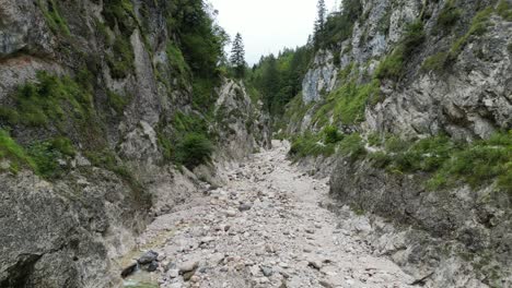 Drohnenblick-Auf-Trockenes-Flussbett-Mit-Felsen-übersät-Almachschlucht-Bayerische-Alpen-Deutschland